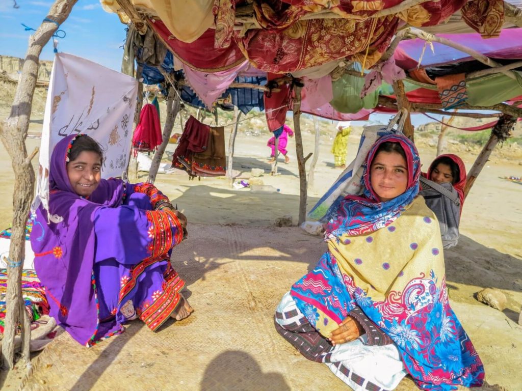 This is a photo of young Baluchi girls resting under a sun shade.