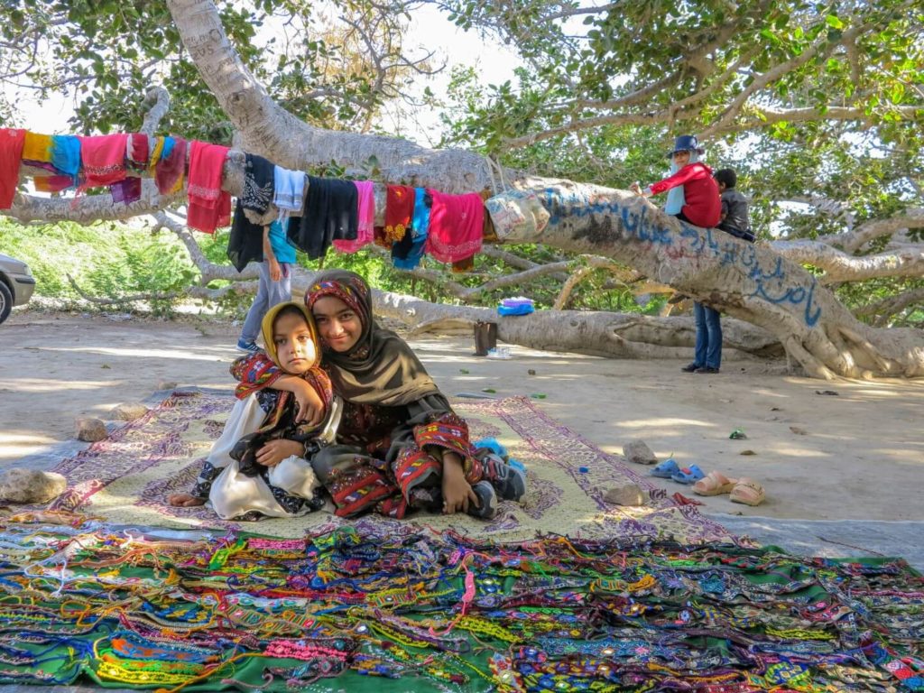 This is a photo of a young women selling colourful handicrafts.