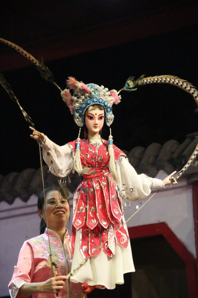 A women holding a traditional Chinese puppet