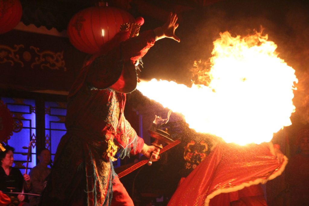 This is a photo of a man spitting fire in a Sichuan opera show.