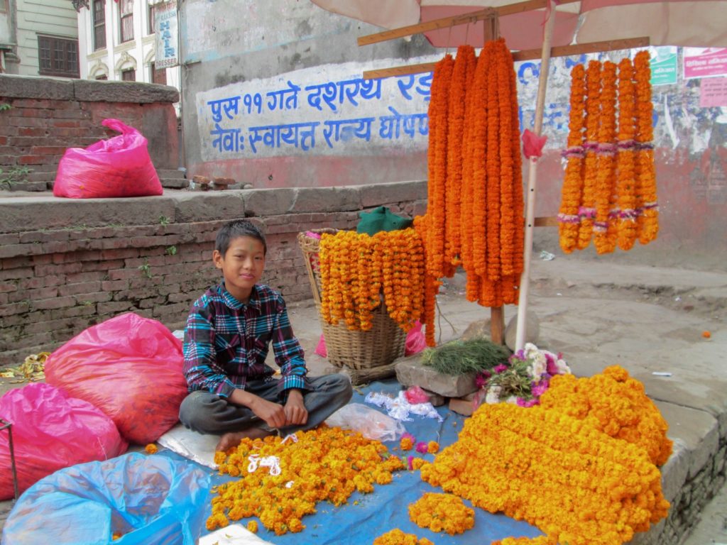 This is a photo of a young boy in Kathmandu selling goods.