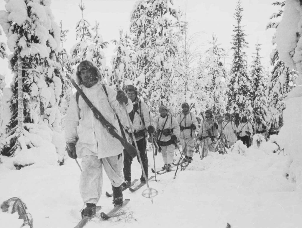 men patroling with skies and guns during Winter War.