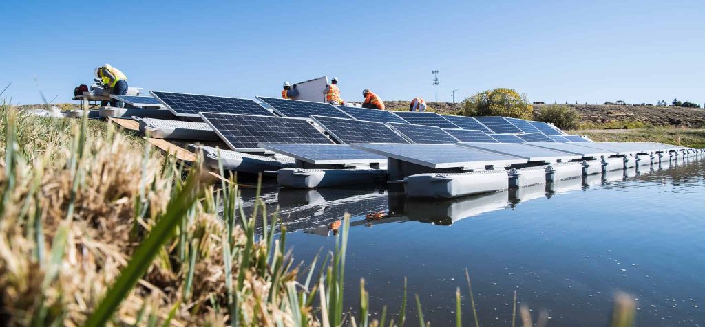 Workers installing Floatovoltaics in Colorado water retention pond