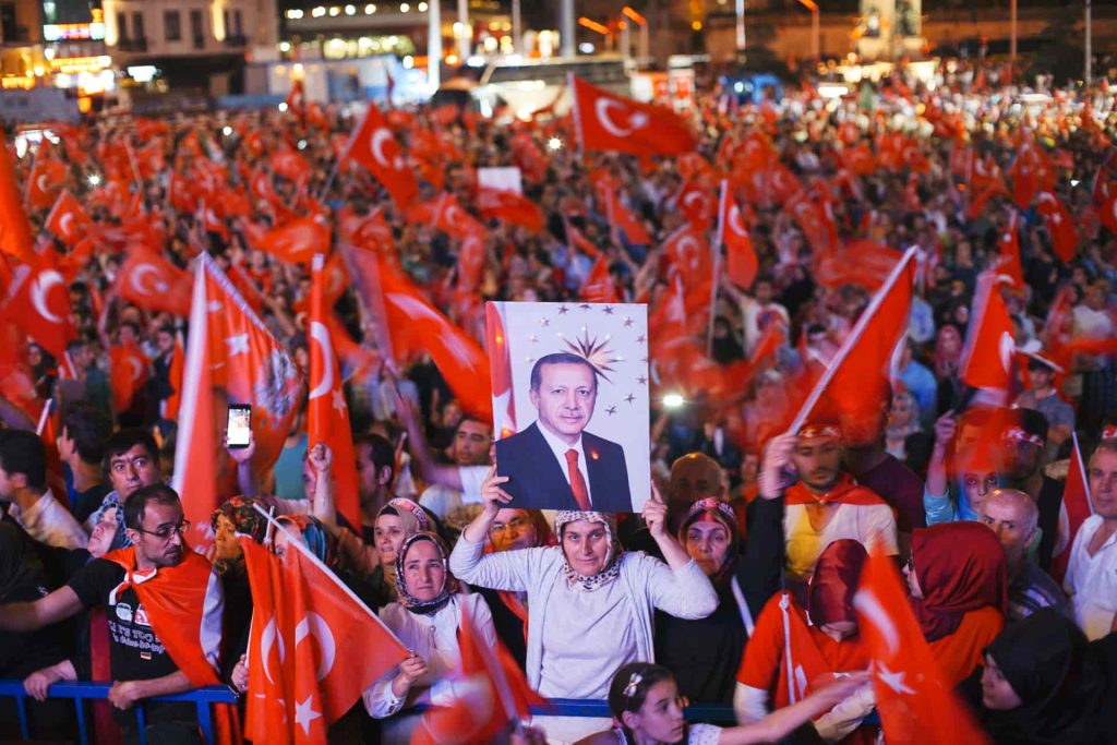 women holding a picture of erdoghan after the 2016 coup